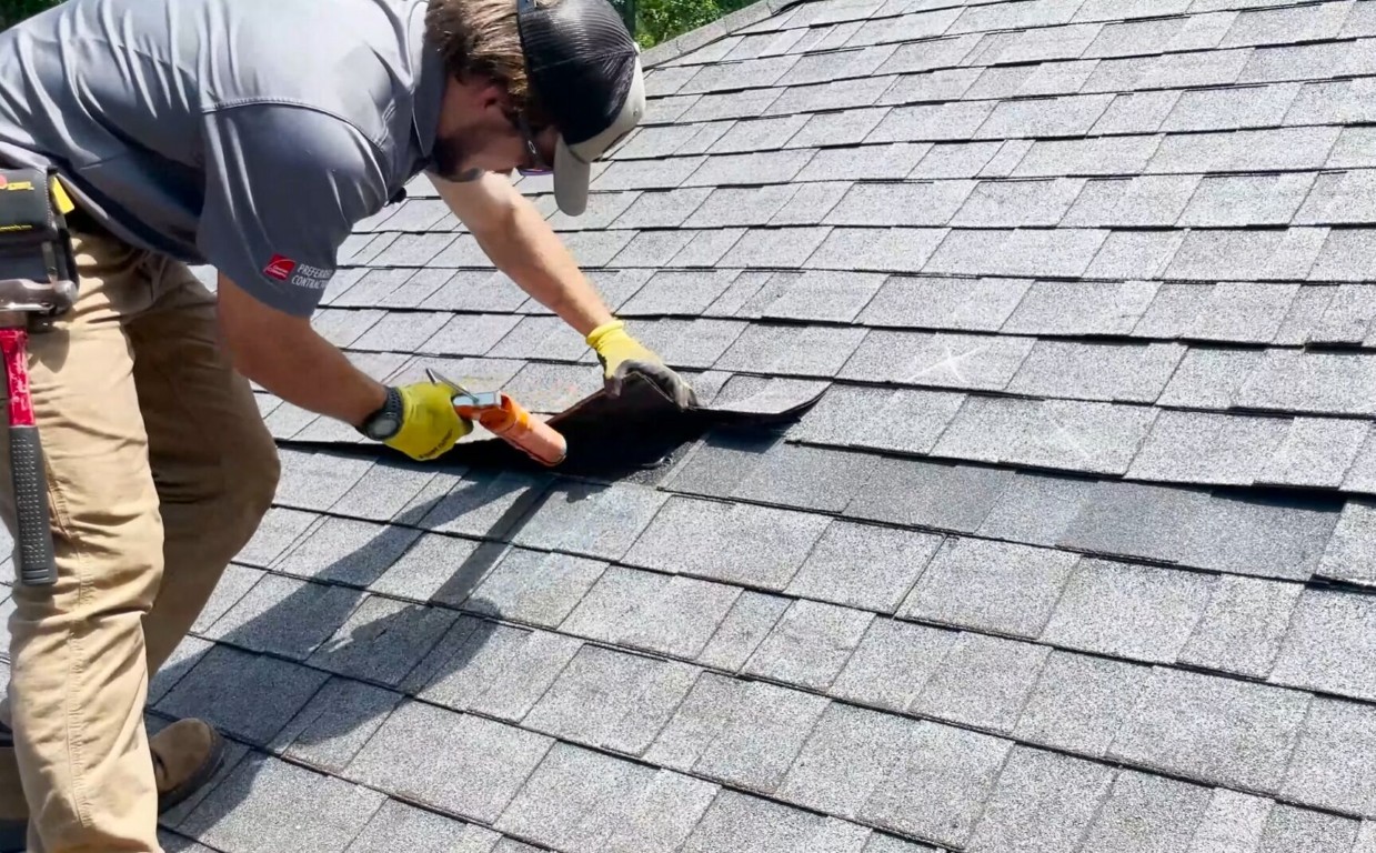 Roofer installing asphalt shingles on residential roof in Coachella, CA